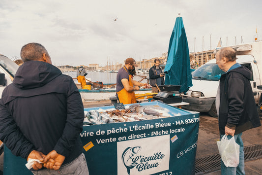 A fish vendor is selling fresh seafood at market.