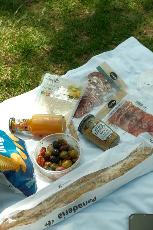 Picnic food is spread out on a blanket.