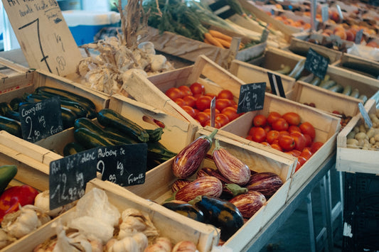 Fresh vegetables displayed in wooden crates at market.